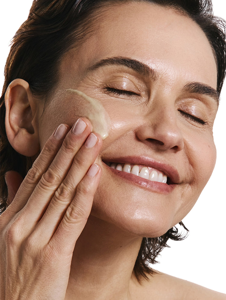 Woman applying a product to her face.