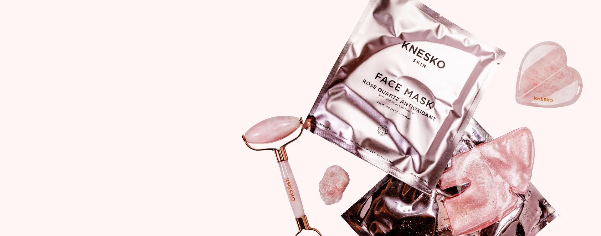 Knesko face mask packaging with a roller and gua sha on a white background