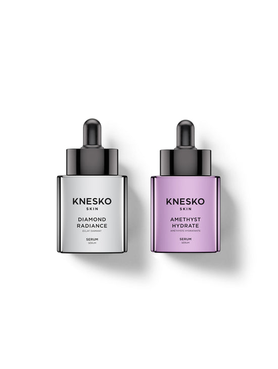 Two Knesko Skin serum dropper bottles on a white background, one with a silver-gray bottle and black dropper, labeled Diamond Radiance, and the other with a lavender-purple bottle and black dropper, labeled Amethyst Hydrate.