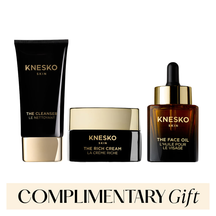 Knesko skincare products including cleanser, cream, and face oil on a white background with 'Complimentary Gift' text.